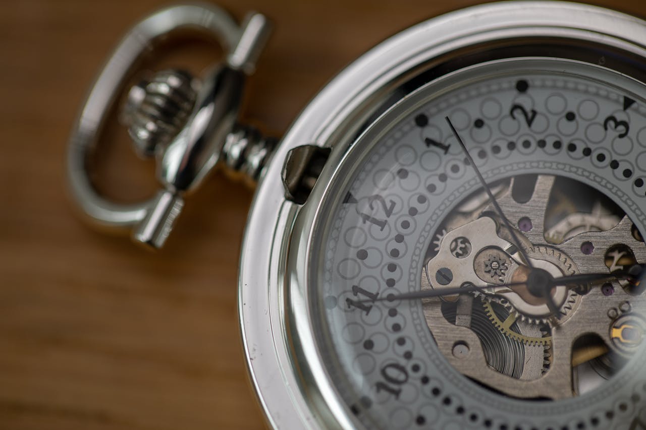 Detailed close-up of a silver skeleton pocket watch showcasing intricate gears and design.